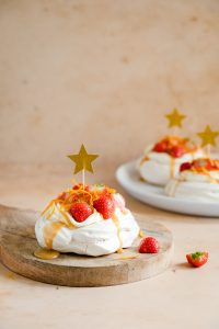 Kaneel pavlova's met aardbeien, karamelsaus en sinaasappelrasp