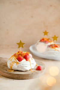 Kaneel pavlova's met aardbeien, karamelsaus en sinaasappelrasp
