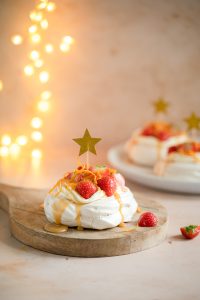Kaneel pavlova's met aardbeien, karamelsaus en sinaasappelrasp