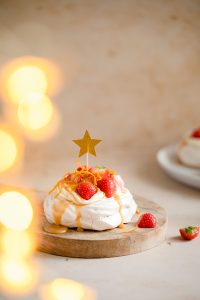 Kaneel pavlova's met aardbeien, karamelsaus en sinaasappelrasp