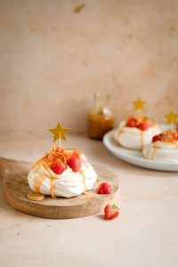 Kaneel pavlova's met aardbeien, karamelsaus en sinaasappelrasp